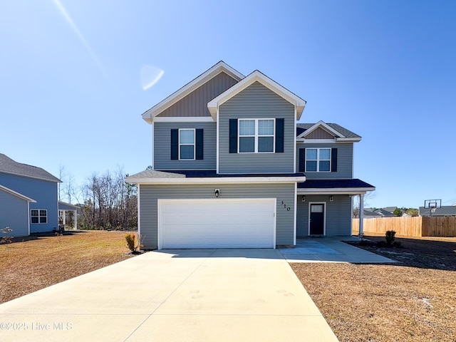 traditional-style house featuring board and batten siding, concrete driveway, a garage, and fence