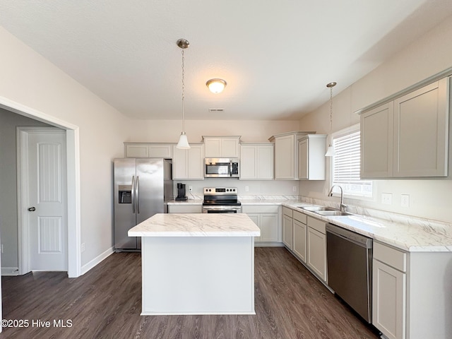 kitchen featuring a sink, appliances with stainless steel finishes, dark wood-style floors, and a center island