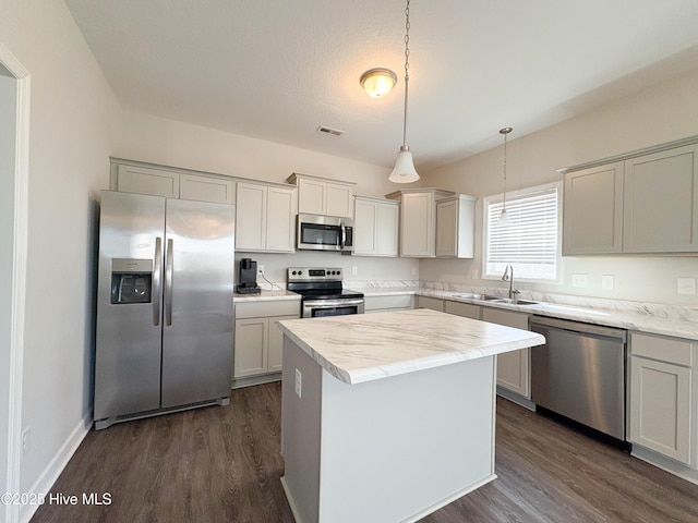 kitchen with dark wood-style flooring, stainless steel appliances, light countertops, and a sink