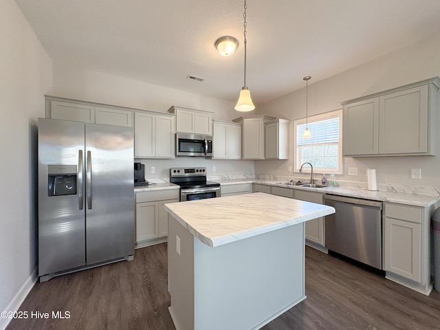 kitchen with dark wood-type flooring, light countertops, appliances with stainless steel finishes, and a sink