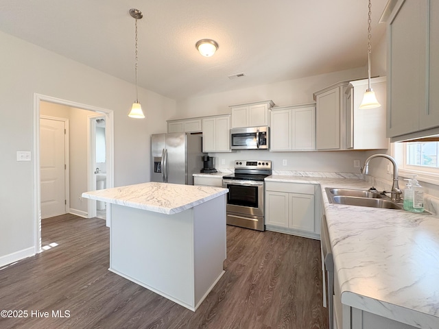 kitchen with visible vents, a sink, a kitchen island, appliances with stainless steel finishes, and dark wood-style flooring