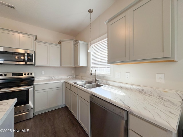 kitchen featuring visible vents, decorative light fixtures, dark wood-style floors, stainless steel appliances, and a sink