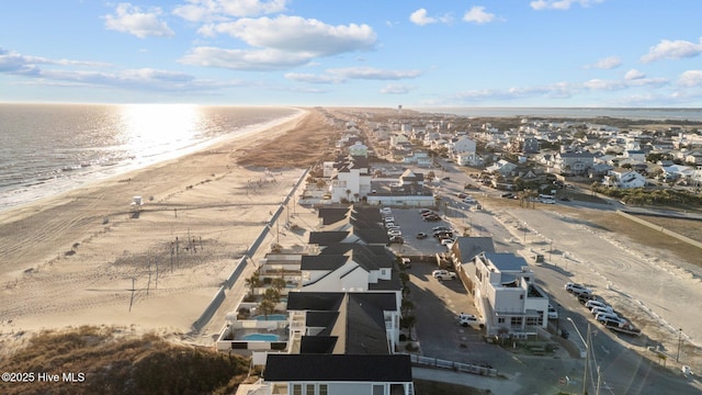 drone / aerial view featuring a beach view, a residential view, and a water view