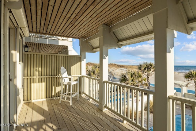 wooden terrace with a water view and a beach view