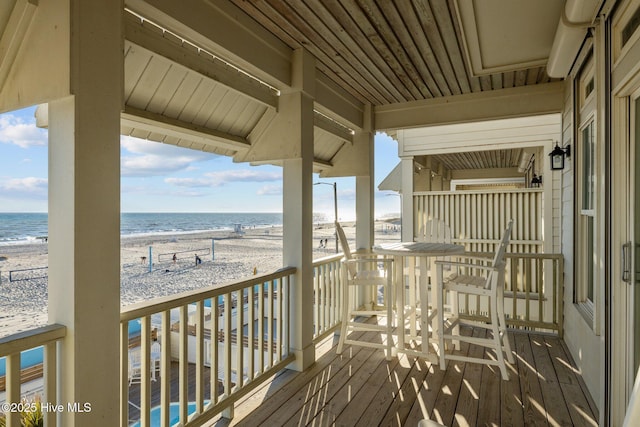 balcony featuring a water view and a beach view