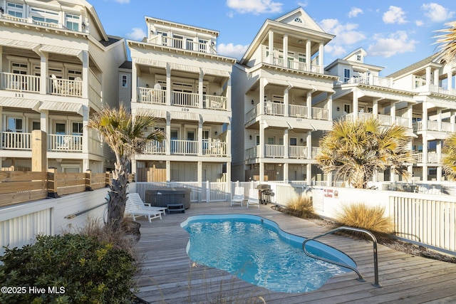 view of swimming pool featuring a fenced in pool, fence, and a hot tub