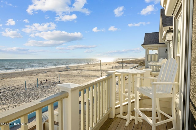 balcony featuring a water view and a view of the beach