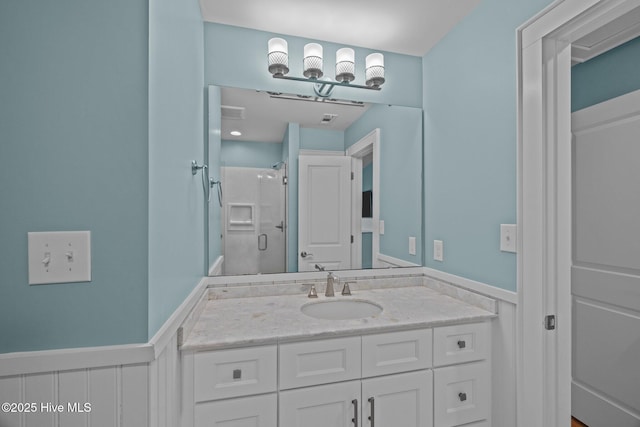 full bath featuring a wainscoted wall, a shower stall, and vanity