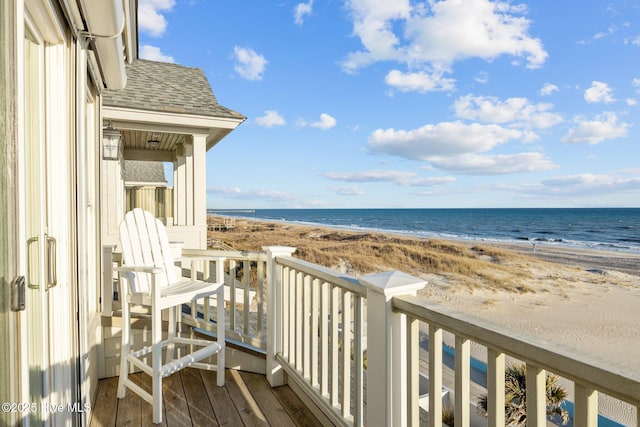 balcony featuring a water view and a view of the beach