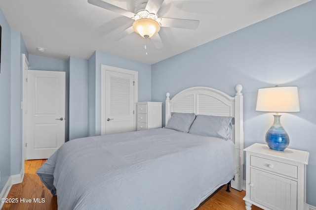 bedroom with ceiling fan, a closet, and wood finished floors