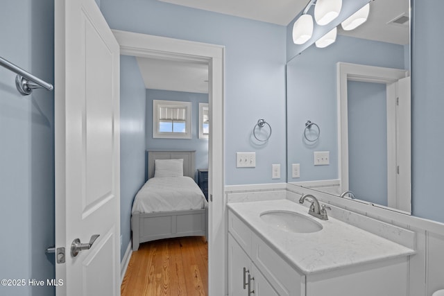 bathroom featuring visible vents, vanity, and wood finished floors