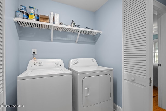 laundry room with laundry area, separate washer and dryer, and wood finished floors