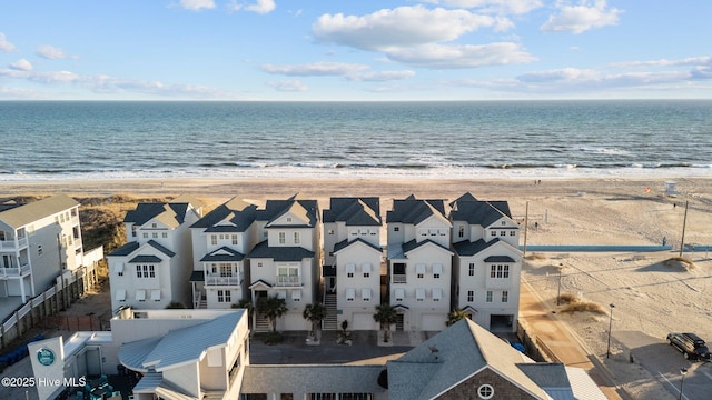 birds eye view of property featuring a view of the beach, a water view, and a residential view