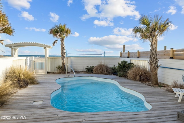 view of pool with fence, a pergola, a fenced in pool, and a wooden deck