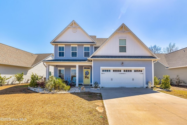 1014 Mccarley Blvd, Wilmington, NC 28412 - view of front of home with board and batten siding, a porch, concrete driveway, a garage, and a front yard