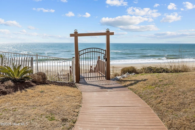 surrounding community featuring a water view, a gate, and a view of the beach