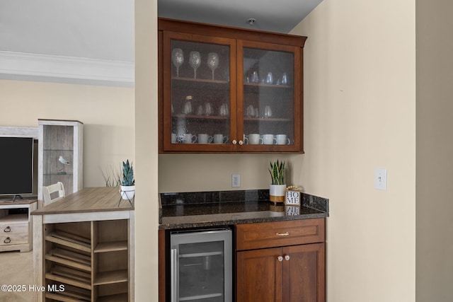 bar featuring beverage cooler, a bar, and ornamental molding