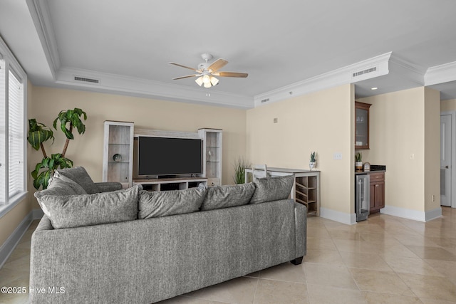 living area with ornamental molding, beverage cooler, visible vents, and baseboards