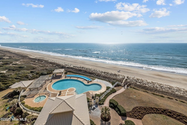 drone / aerial view featuring a water view and a view of the beach