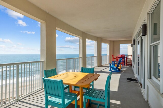 balcony with a water view and a beach view