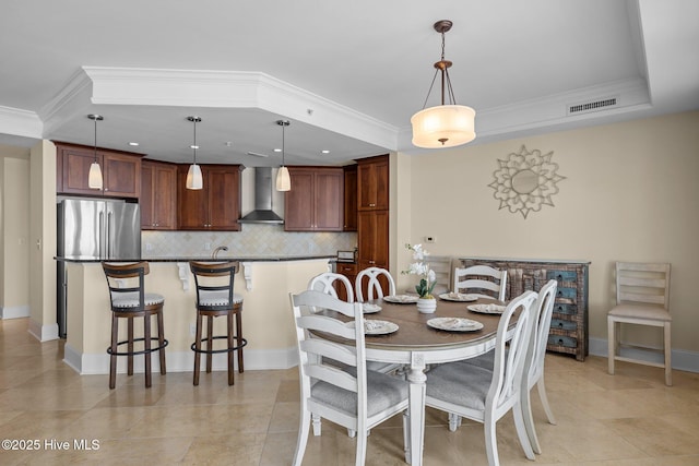 dining area with light tile patterned floors, ornamental molding, visible vents, and baseboards