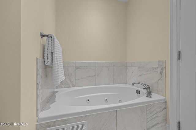 bathroom featuring a jetted tub and visible vents