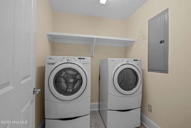 washroom featuring laundry area, washing machine and dryer, electric panel, and baseboards