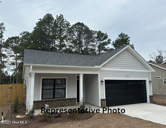 view of front of home with a garage, driveway, a shingled roof, and a porch