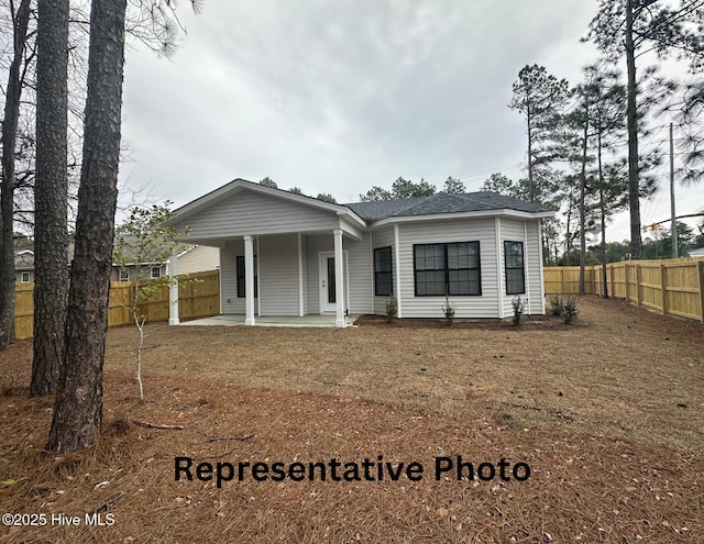 view of front of property featuring a shingled roof and fence