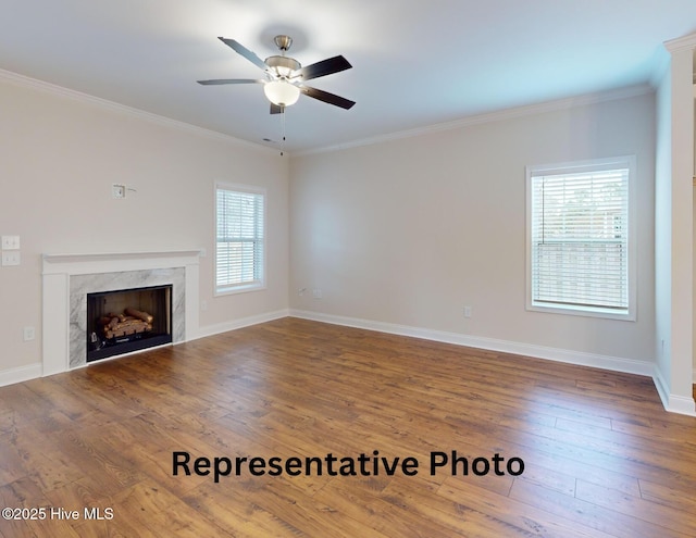 unfurnished living room featuring ornamental molding, plenty of natural light, and hardwood / wood-style flooring