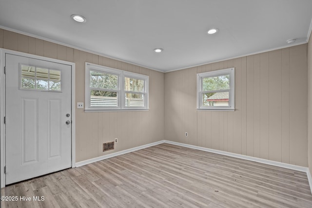 foyer with crown molding, recessed lighting, visible vents, light wood-type flooring, and baseboards