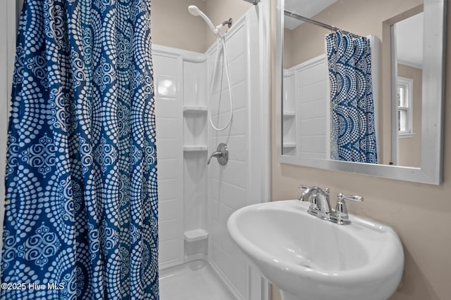 bathroom featuring curtained shower and a sink