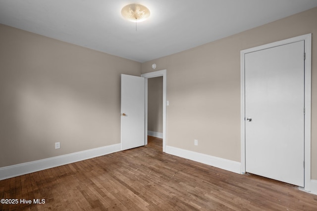 unfurnished bedroom featuring baseboards and wood finished floors