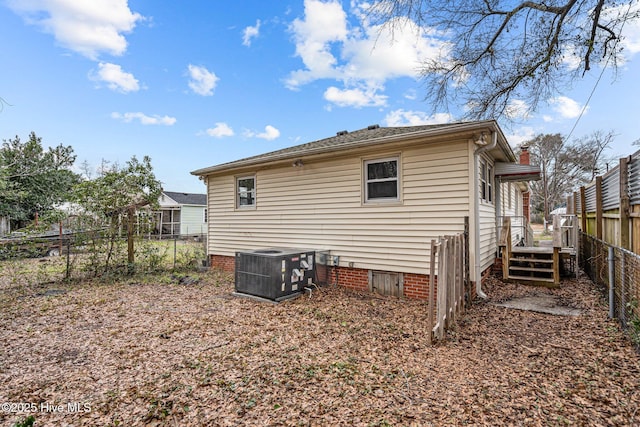 rear view of property with crawl space, fence, and central AC