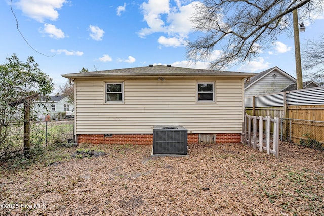 rear view of property featuring crawl space, a fenced backyard, and central AC unit