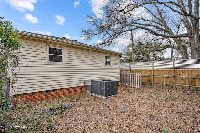 view of home's exterior featuring crawl space, fence, and central AC unit