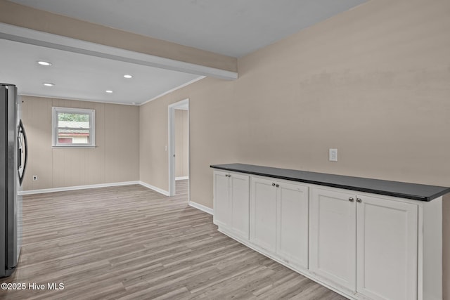 interior space with baseboards, ornamental molding, freestanding refrigerator, light wood-style floors, and recessed lighting