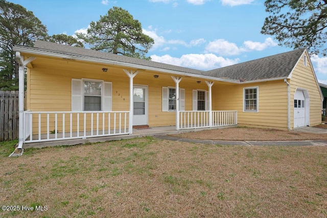 ranch-style home with a porch, a shingled roof, a front yard, fence, and a garage