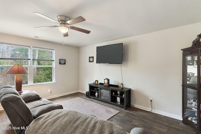 living room featuring a ceiling fan, dark wood finished floors, visible vents, and baseboards