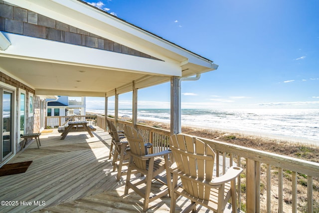 deck with a view of the beach and a water view