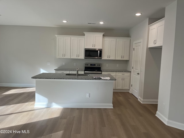 kitchen featuring white cabinets, dark wood-style floors, stainless steel appliances, and dark stone countertops