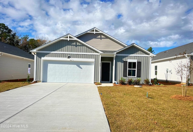 view of front of property featuring a garage, driveway, board and batten siding, and a front yard