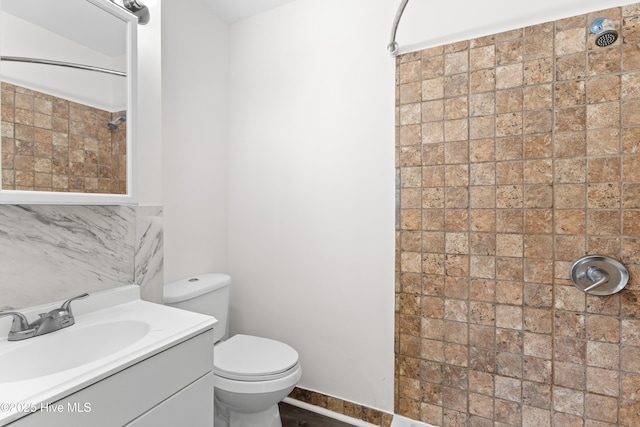 full bathroom featuring a shower, vanity, and toilet