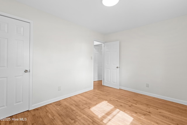 unfurnished bedroom with light wood-style flooring and baseboards