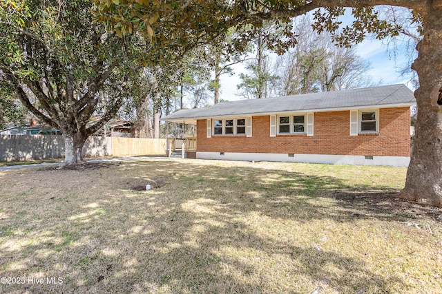 back of property with crawl space, fence, a lawn, and brick siding