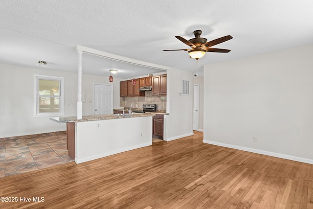 kitchen with tasteful backsplash, visible vents, ceiling fan, stainless steel electric stove, and light wood-style floors