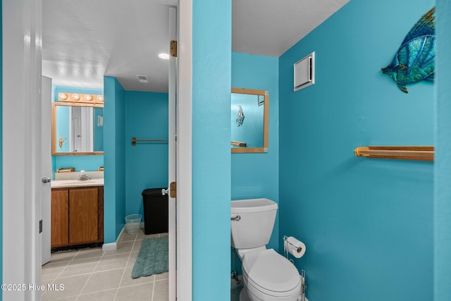 bathroom featuring tile patterned flooring, baseboards, vanity, and toilet