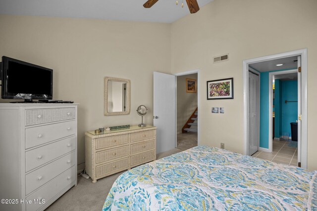 bedroom with visible vents, connected bathroom, light colored carpet, ceiling fan, and high vaulted ceiling