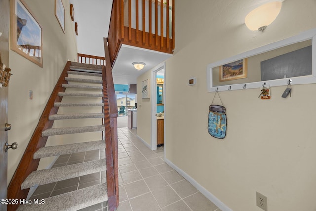 stairway featuring baseboards and tile patterned floors