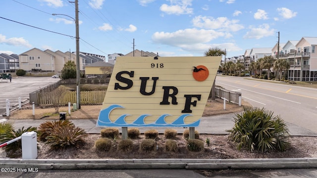 community sign with fence and a residential view